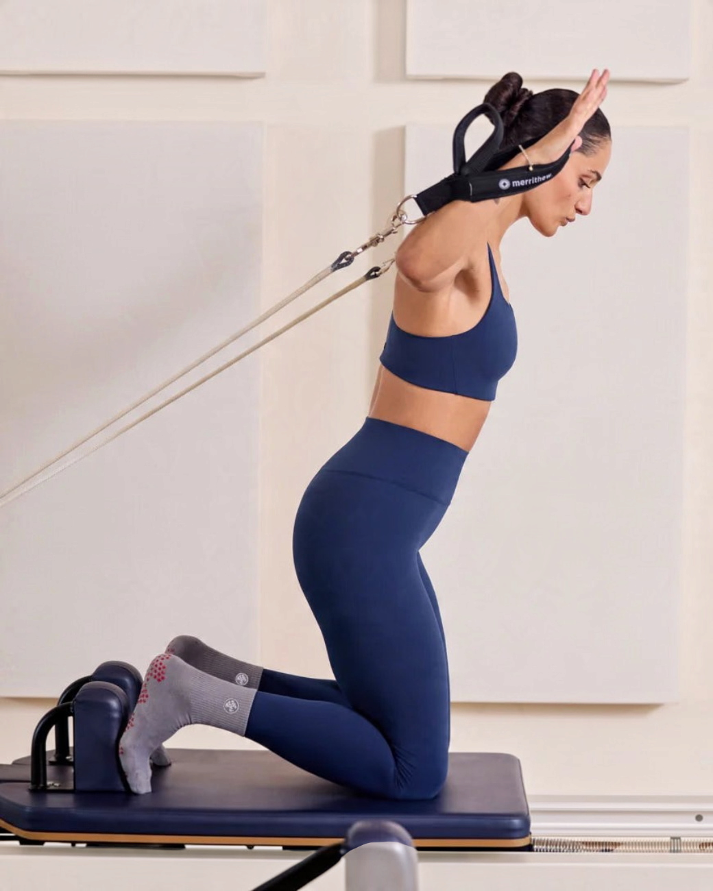 greenyogashop Equilibria Pilates Socken in Grau mit rotem Silikon-Grip beim Training auf dem Reformer