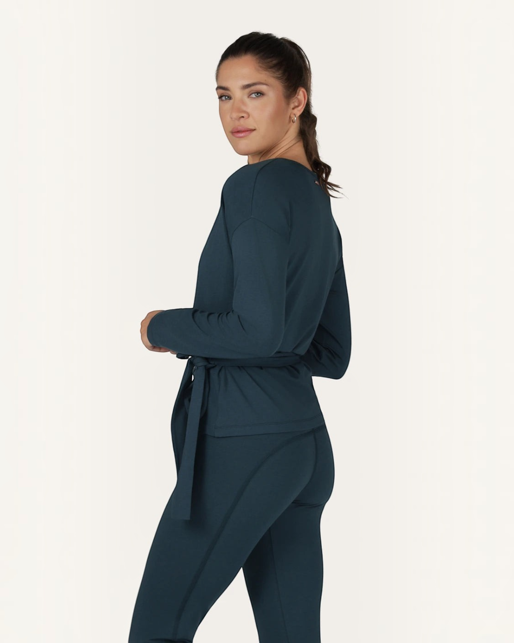 Model trägt grüne greenyogashop Aurora Wickeljacke aus weichem Bambus-Mix mit Bindeband in Seitenansicht