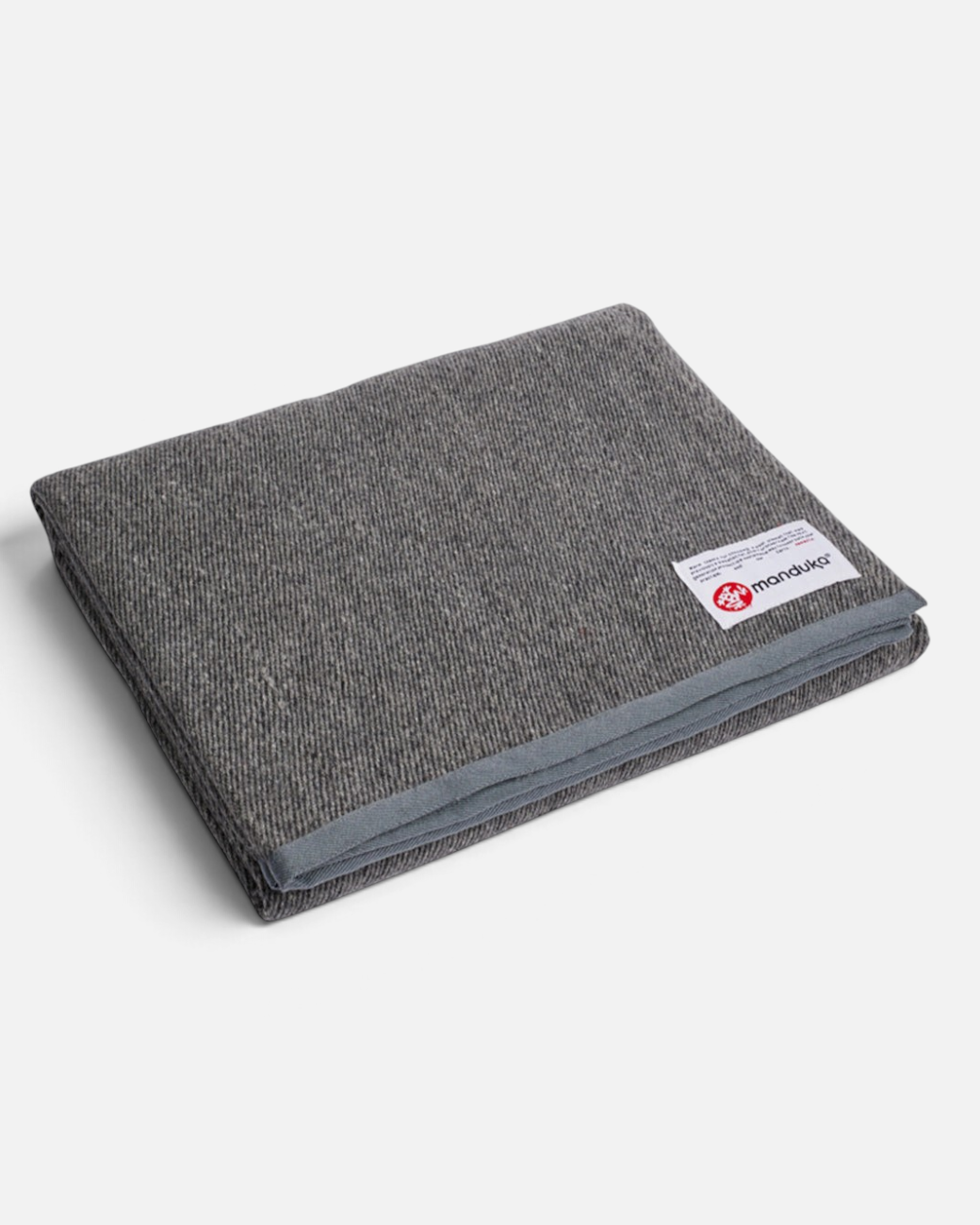 greenyogashop Decke aus recycelter Wolle in Sediment Grau mit genähten Kanten und Manduka Logo-Label