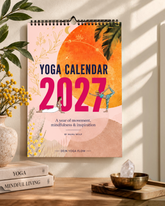 greenyogashop Yoga-Kalender 2027 mit inspirierenden Illustrationen, hängend an einer Wand über Büchern und Deko