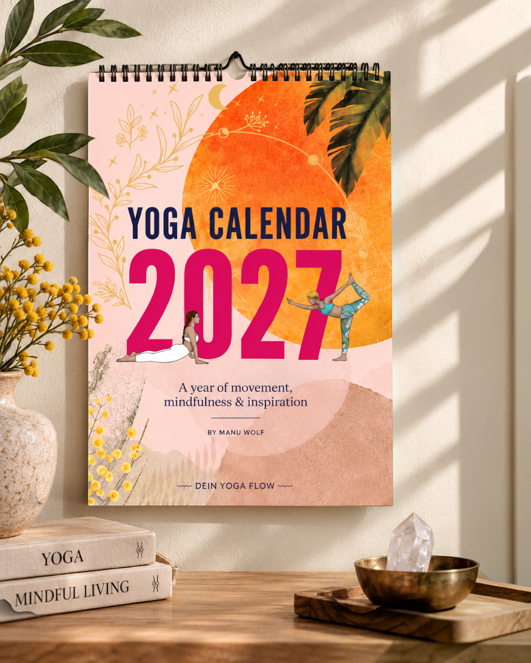 greenyogashop Yoga-Kalender 2027 mit inspirierenden Illustrationen, hängend an einer Wand über Büchern und Deko