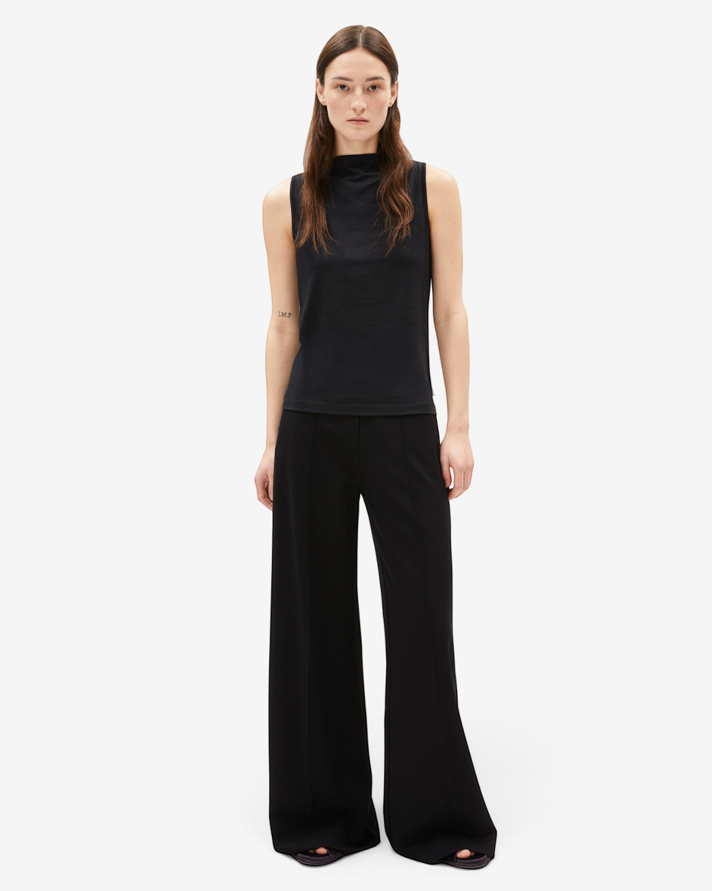 greenyogashop ärmelloses schwarzes Top LAMINIAA aus TENCEL und Bio-Baumwolle mit Boot-Ausschnitt an einem Model