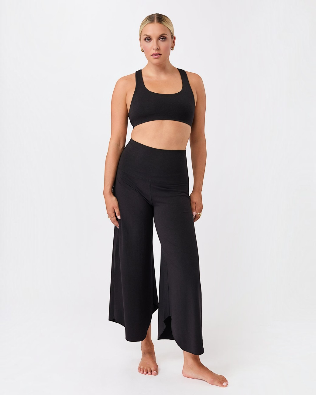 Model trägt schwarze greenyogashop Hose Roll Over Tulip mit weitem Bein und 7/8-Länge aus Lyocell-Baumwoll-Mix