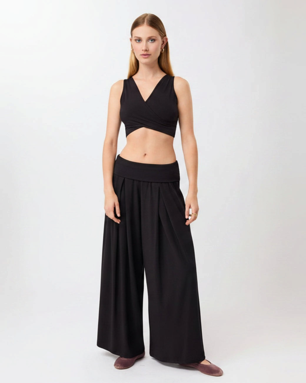 Model trägt schwarze greenyogashop Lounge Pants mit weitem Schnitt, elastischem Bund und weichem Baumwoll-Mix-Material
