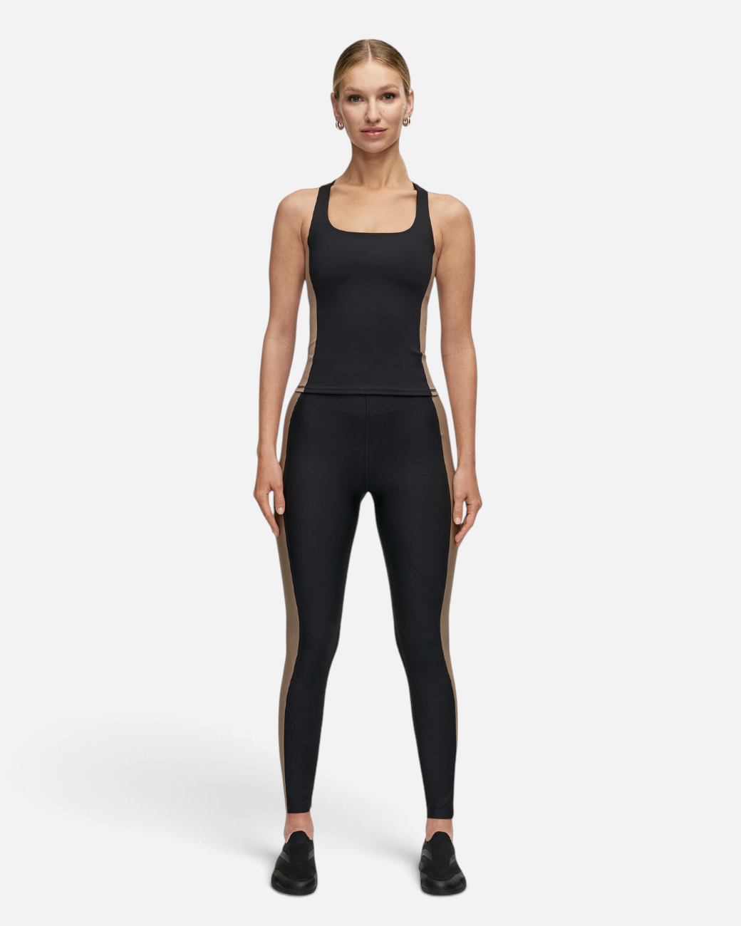 Model trägt greenyogashop Shaped Block High Waist Leggings in Schwarz mit kontrastfarbenen Seiteneinsätzen