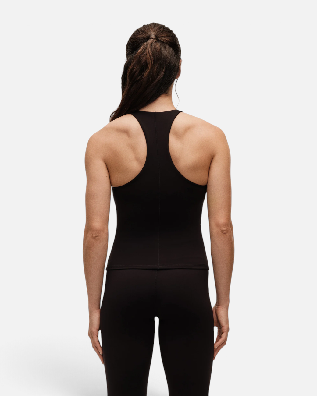 greenyogashop schwarzes Tanktop mit integriertem BH und Racerback-Design, getragen von einer Frau von hinten