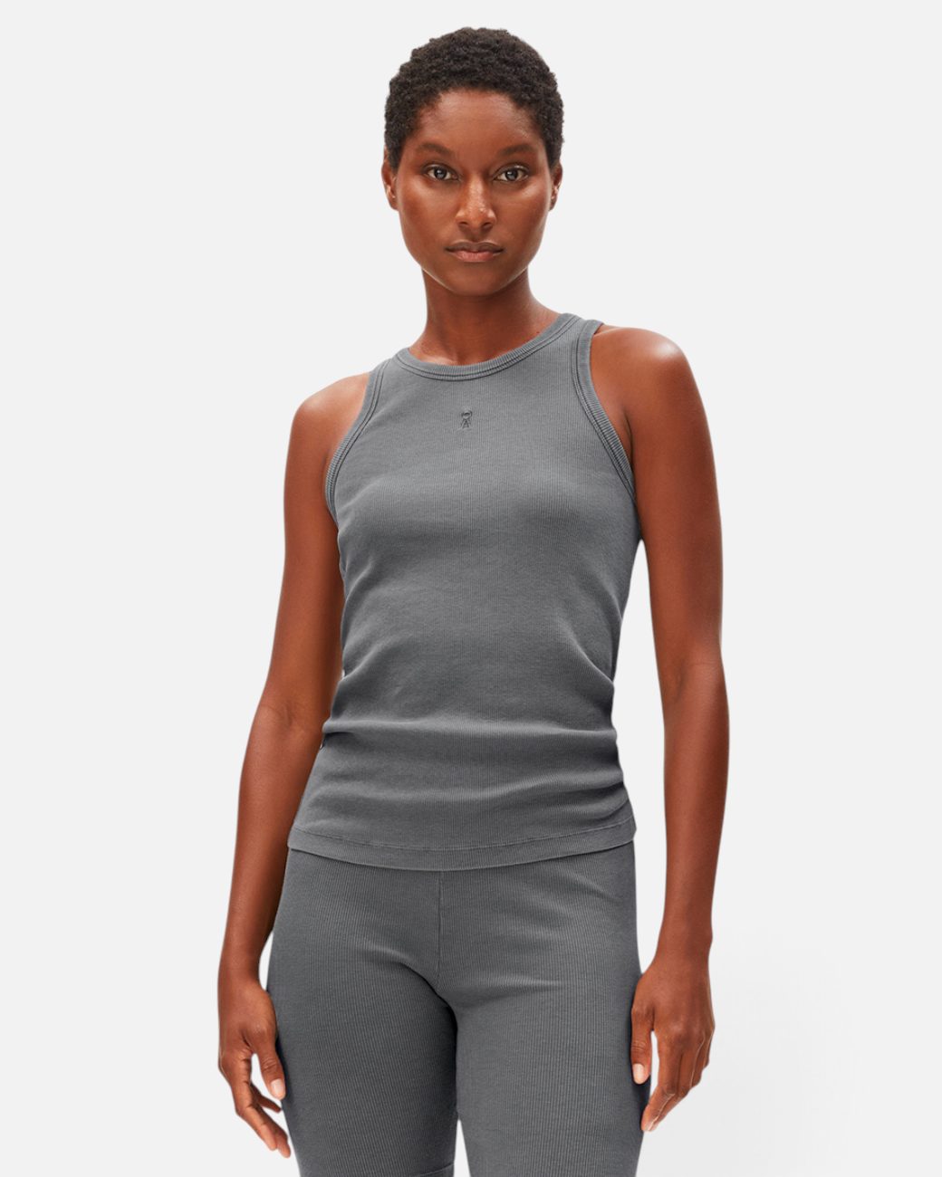 Model trägt ein graues, ärmelloses greenyogashop GMT Dye Ripp-Top aus Bio-Baumwolle mit Rundhalsausschnitt und Logo