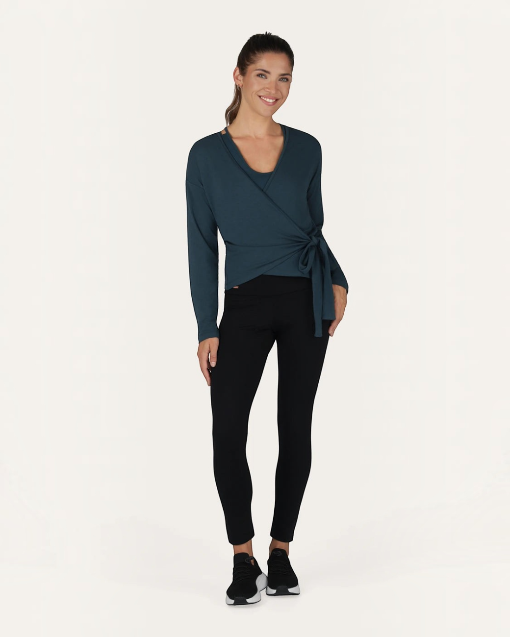 Model trägt grüne greenyogashop Aurora Wickeljacke aus Bambus-Mix mit Bindeband für Yoga und Alltag